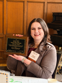 Alaina Humphreys holding award plaque