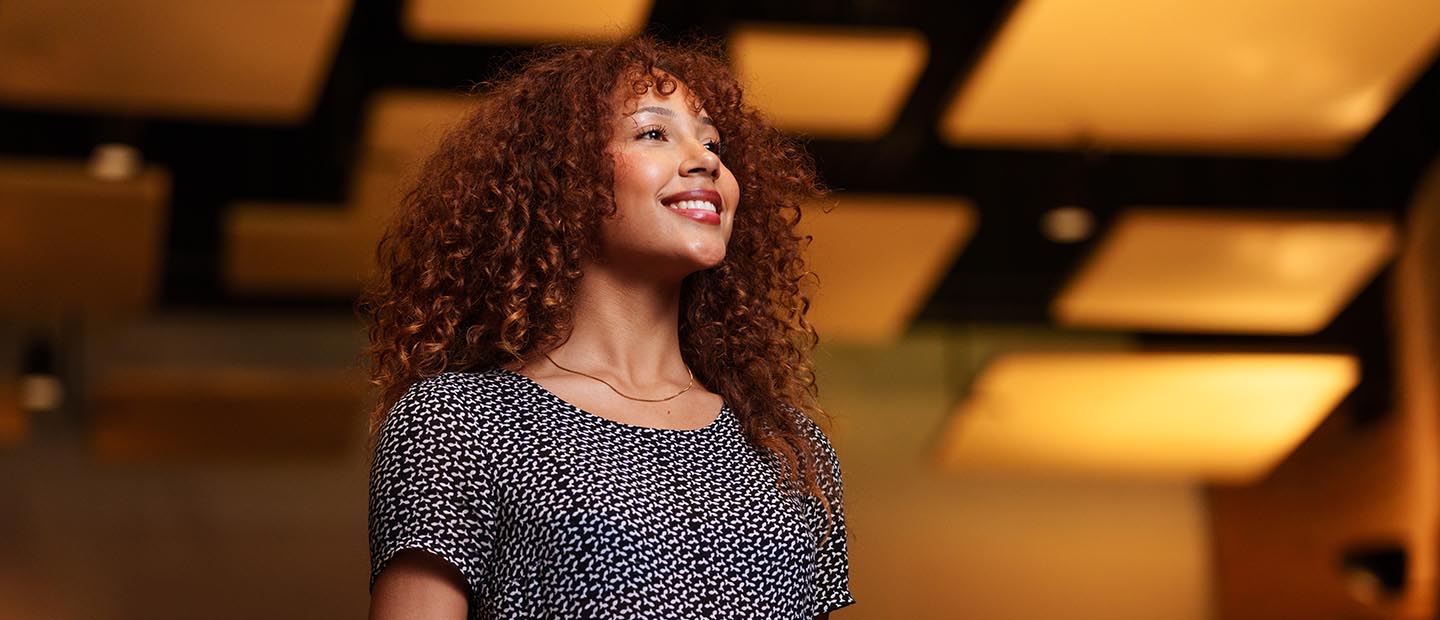 A woman smiling and looking off in the distance