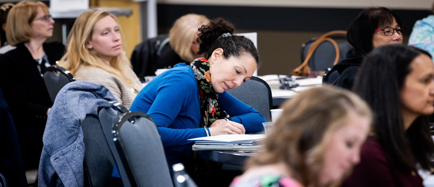 Professionals take notes at lecture