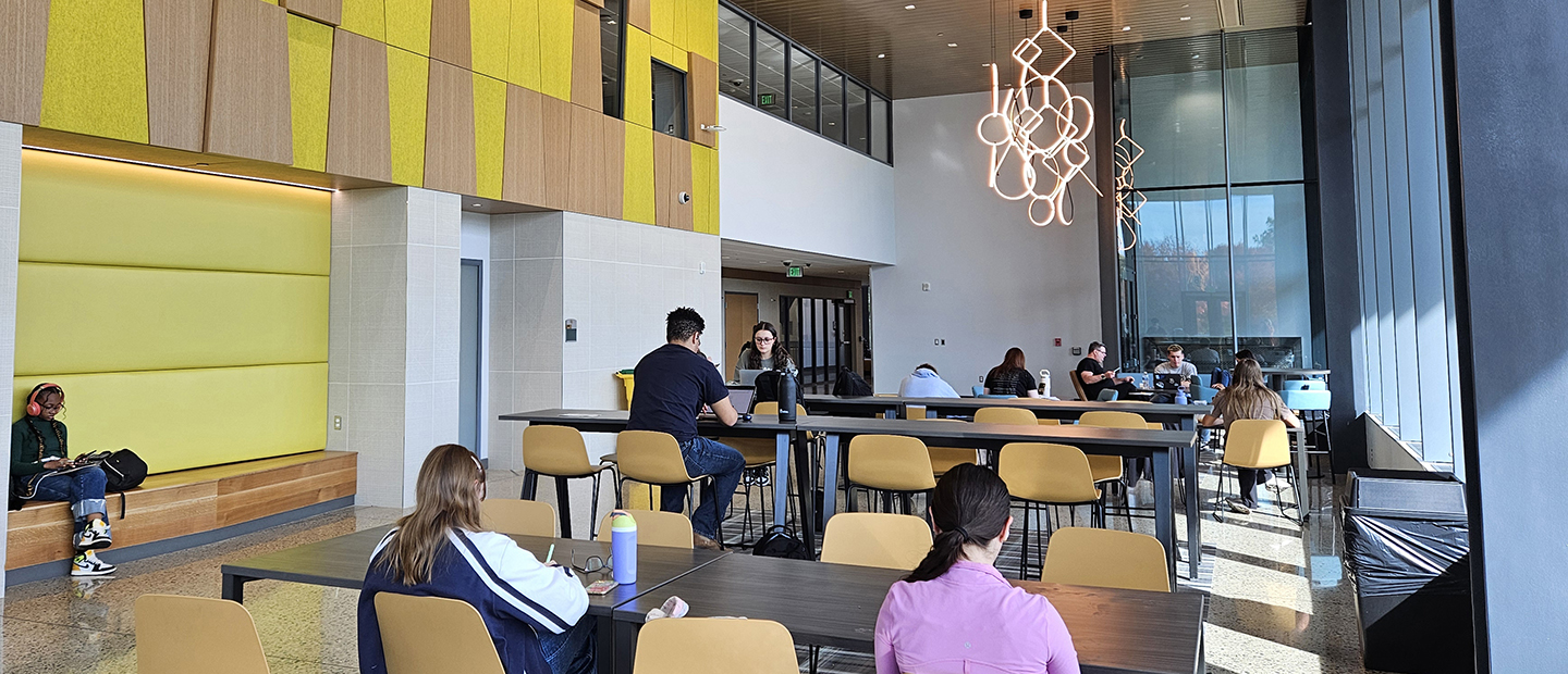 Students seated in a common area in a building at Oakland University