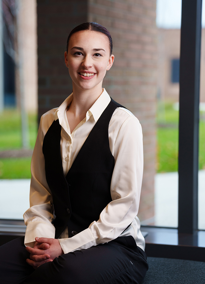 June Wallace poses for a photo in front of a window in Varner Hall.