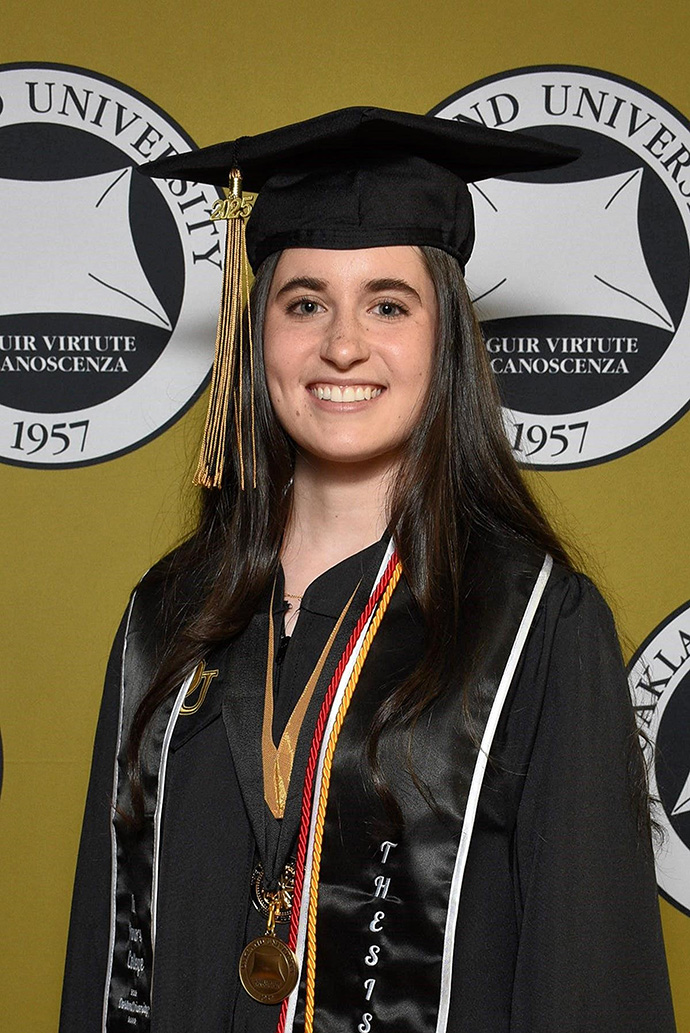 Emily Smeu poses for a photo in her gap and gown at the Oakland University commencement
