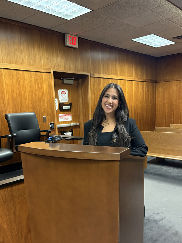 Oakland Political Science student Maria Williams stands in an empty courtroom.