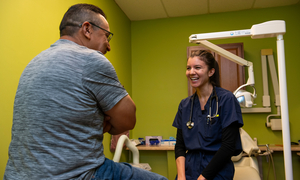 An OUWB student talking to a patient