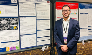 A student in front of his research poster