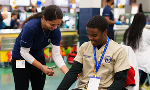 A student helping a patient at a community event