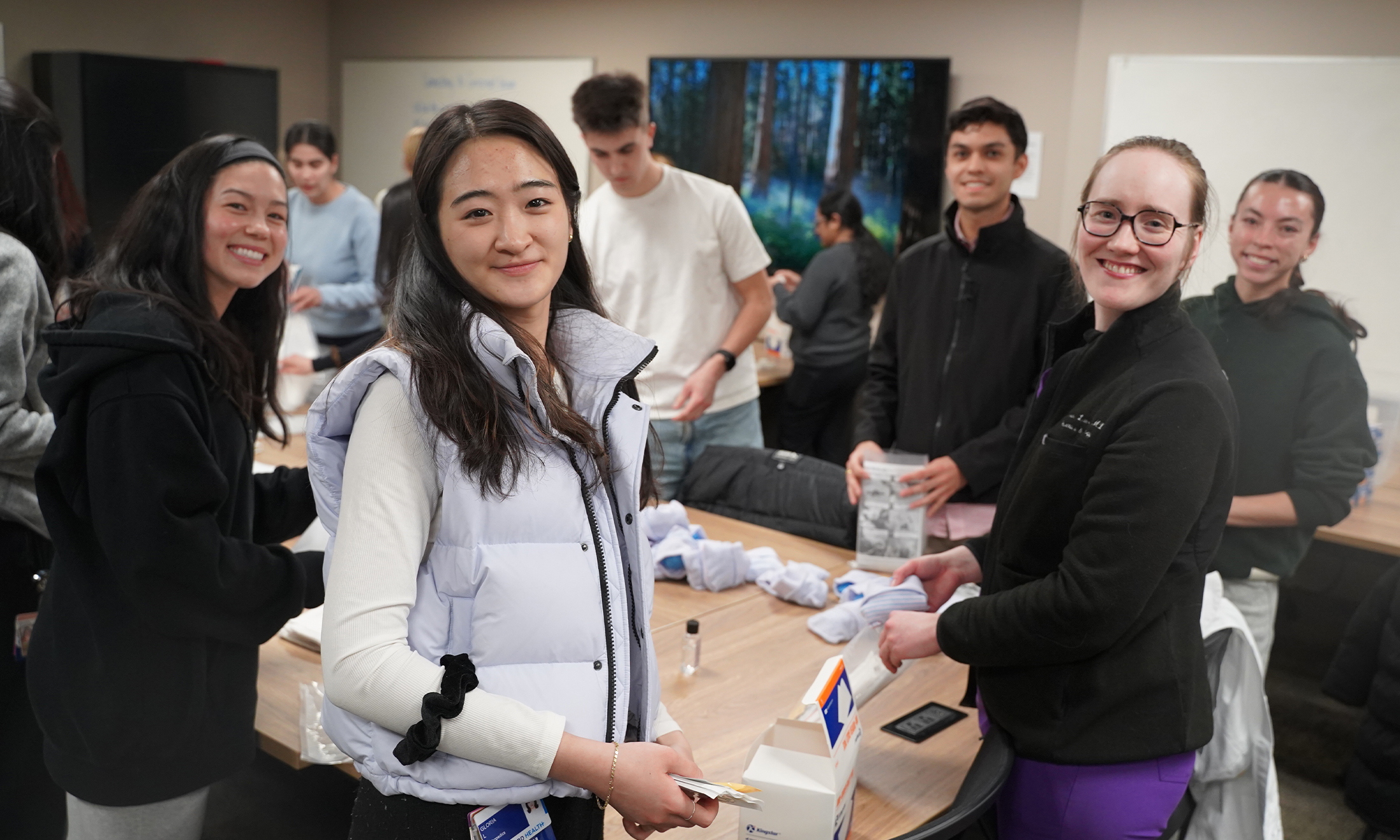 Students pose for a picture while assembling clean birth kits