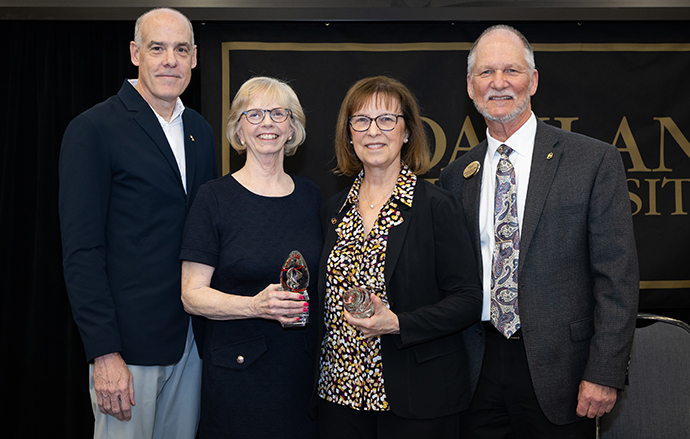 Two women hold awards, pictured with the Dean and Department Chair