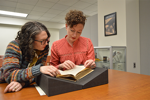 Megan Peiser and Emily Spunaugle looking at book