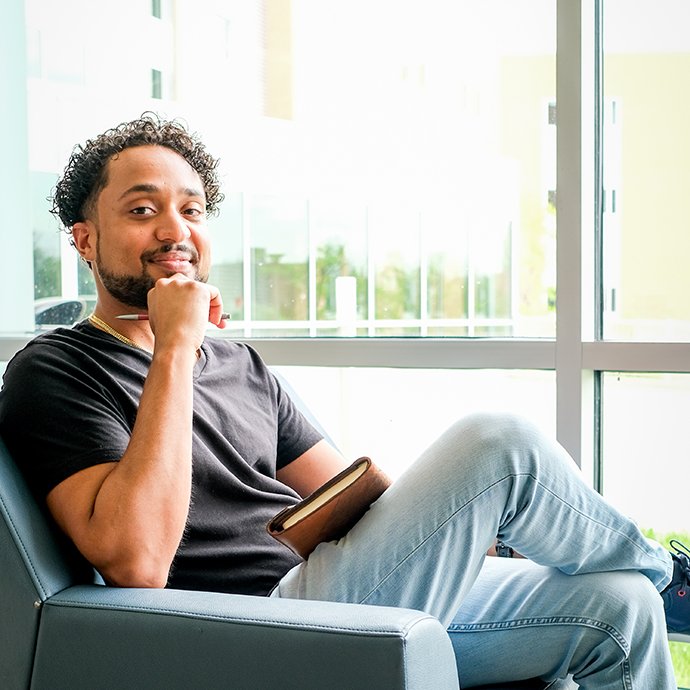A man sitting in a chair holding a pencil