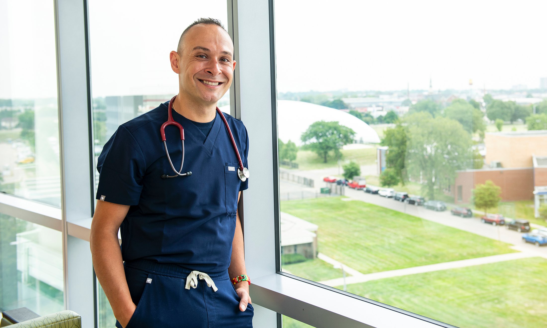 A nurse wearing a stethoscope next to a window