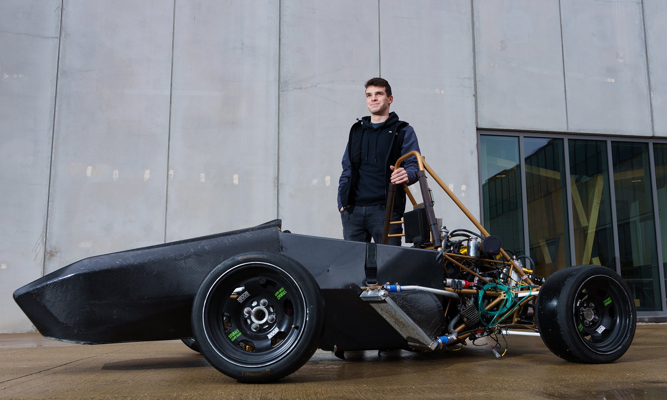 A man in front of an SAE car