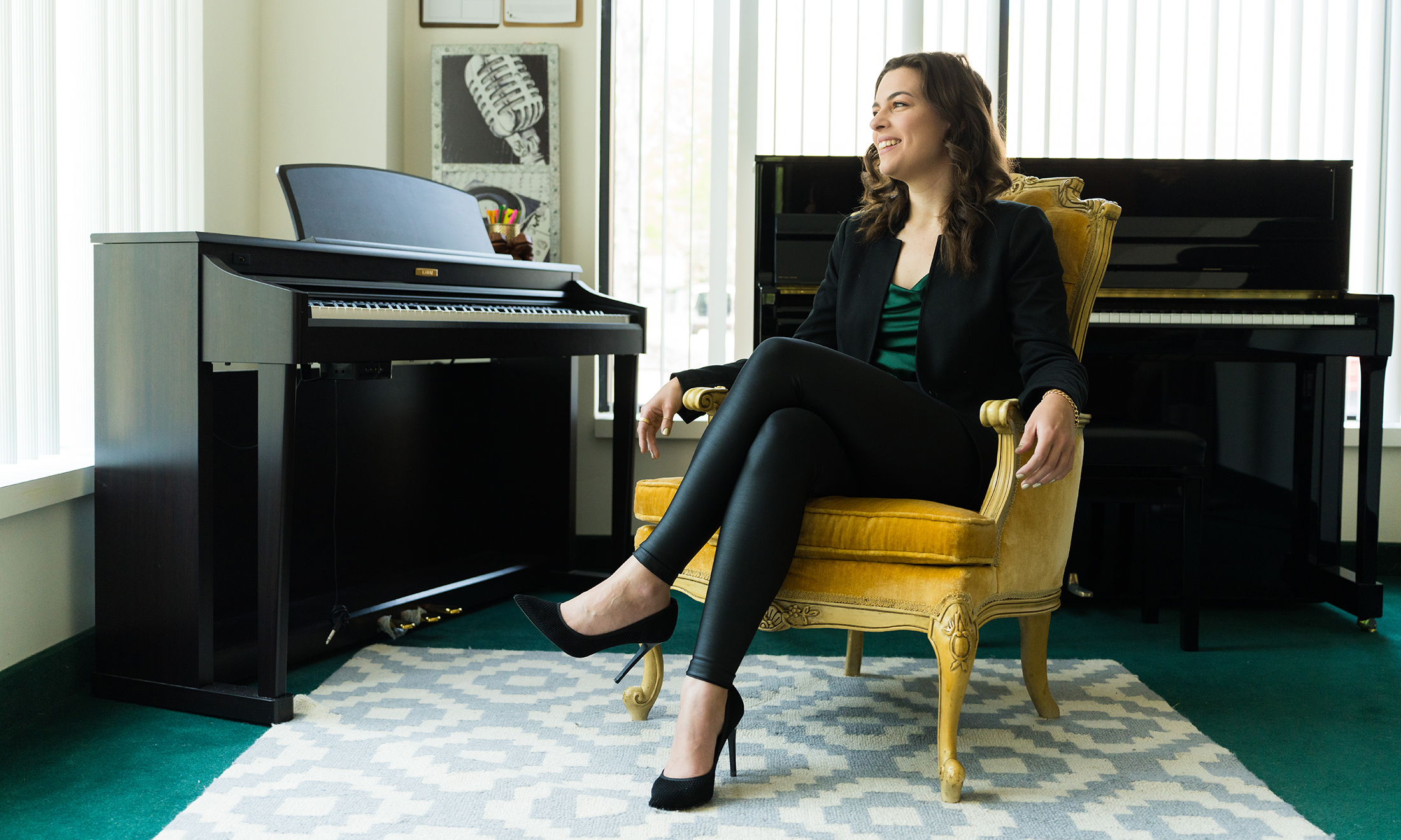 A woman sitting in the gold seat in front of two pianos