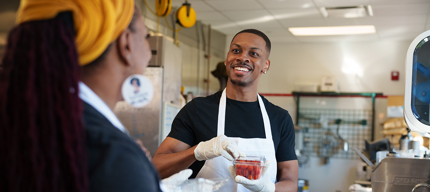 A student holding a carton of cherry tomatoes.