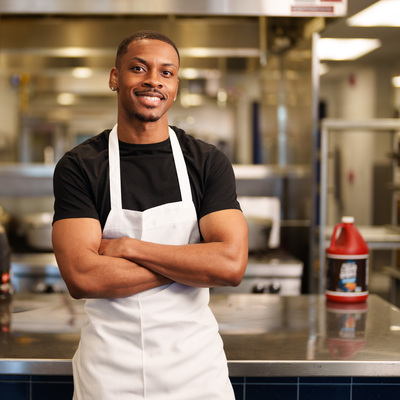Michael Dotson-Branch wearing an apron, posing for a photo.