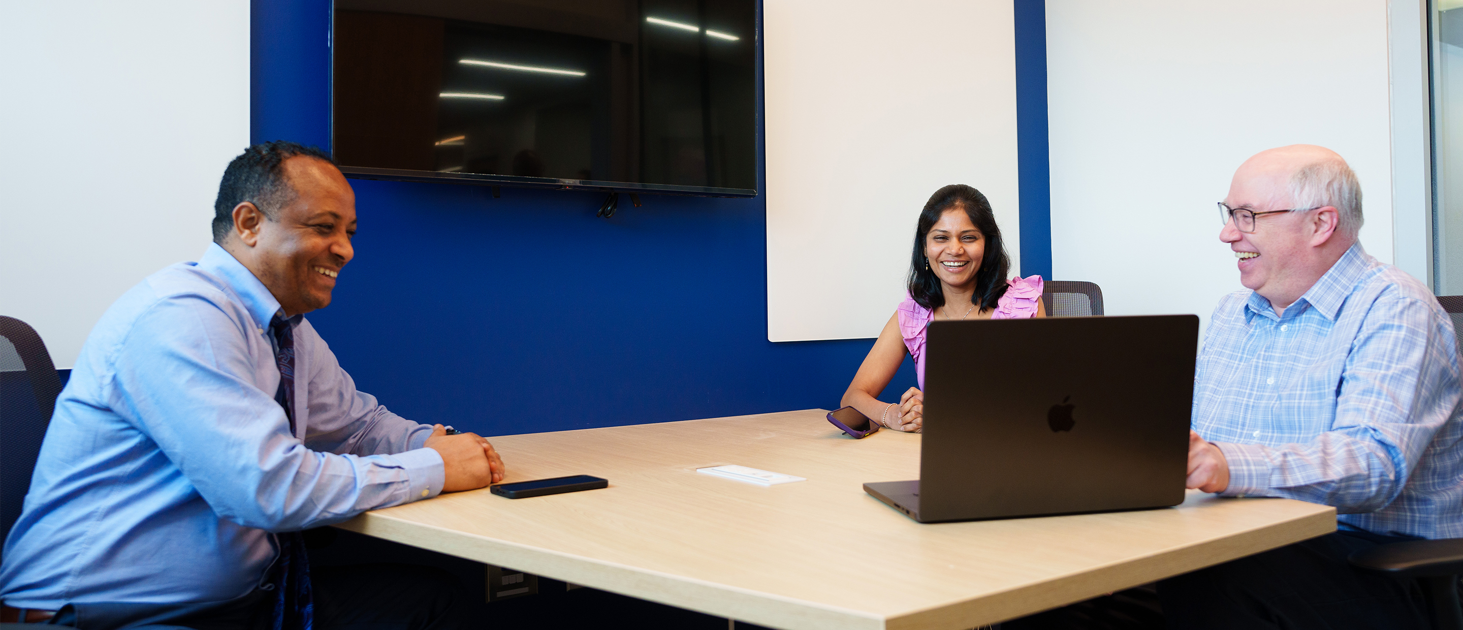 An image of three faculty members sitting at a table