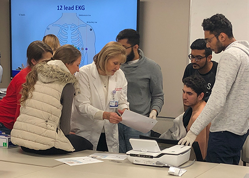 An image of students listening to a doctor