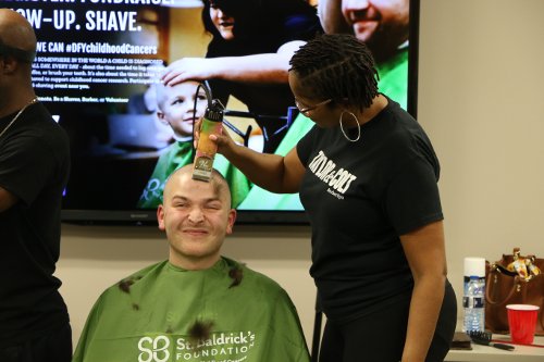 An image of a man having his head shaved