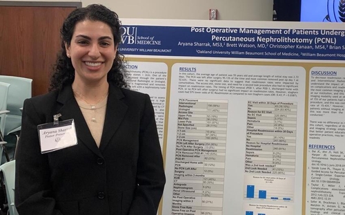 An image of a student in front of a poster