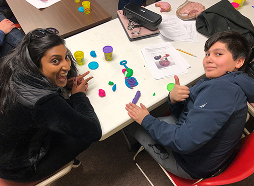An image of a medical student and younger person at a table