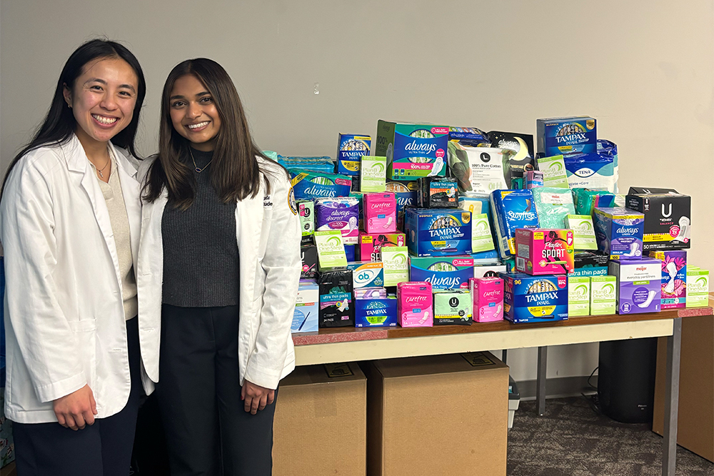 Two students in front of products they helped collect