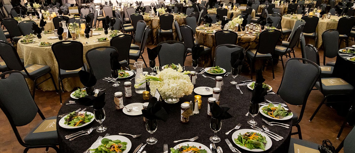 empty banquet room with salads at place settings