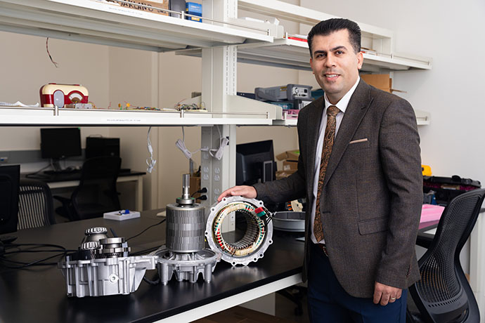 a professor posing next to equipment
