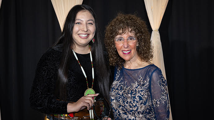 A Native American woman posing with an award