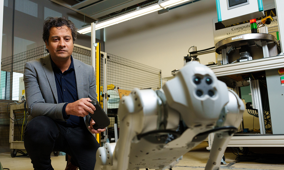professor holding a control for a robot-dog