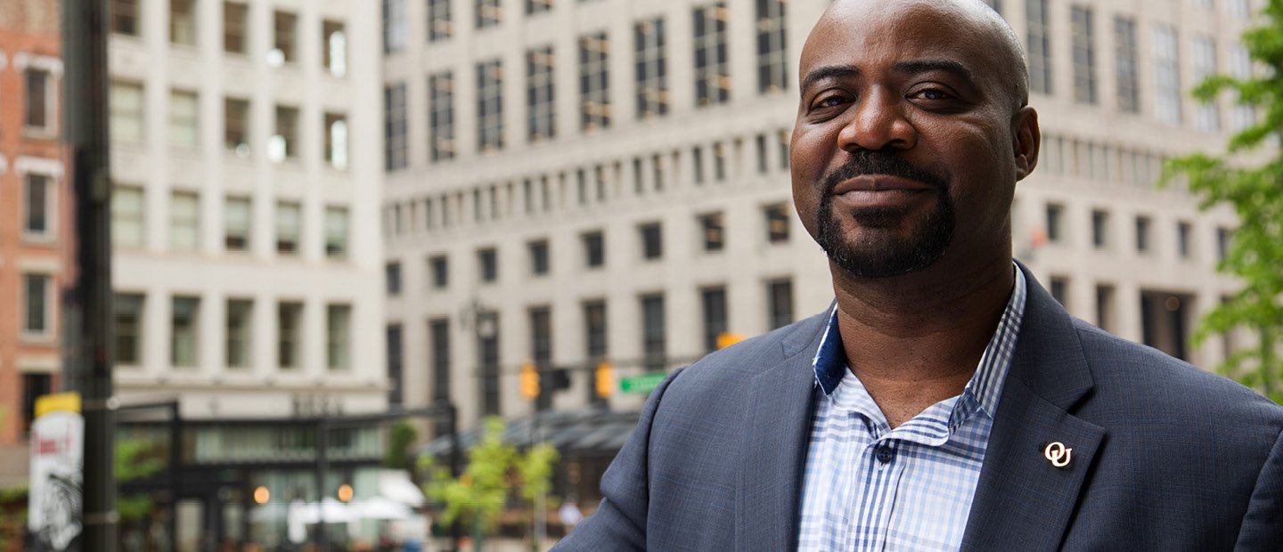 Man standing outside in a downtown area in the middle of the day