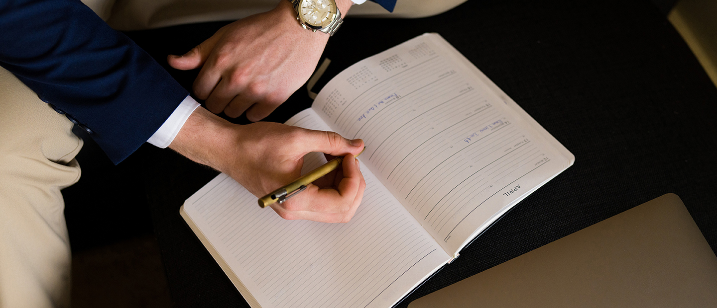 Hands writing in a notebook