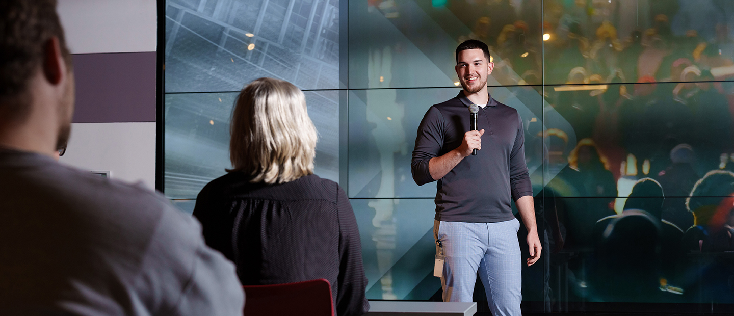 A man holding a microphone, presenting