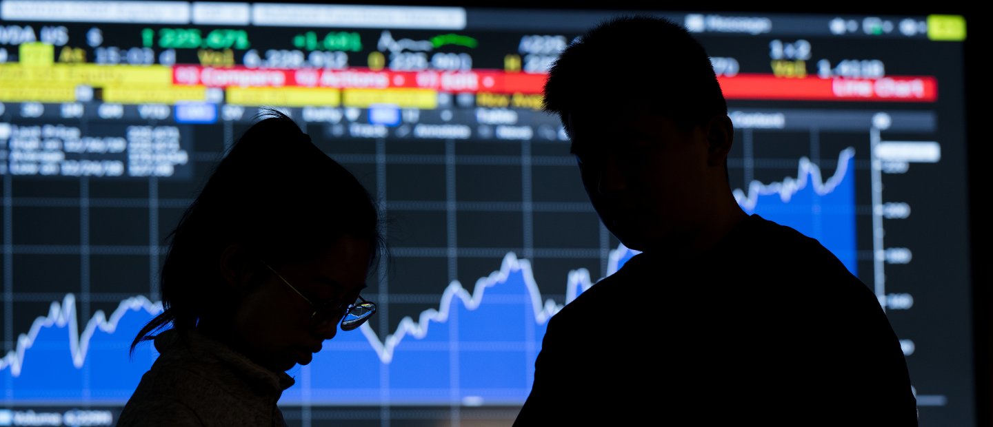 2 dark silhouettes in front of graph presentation