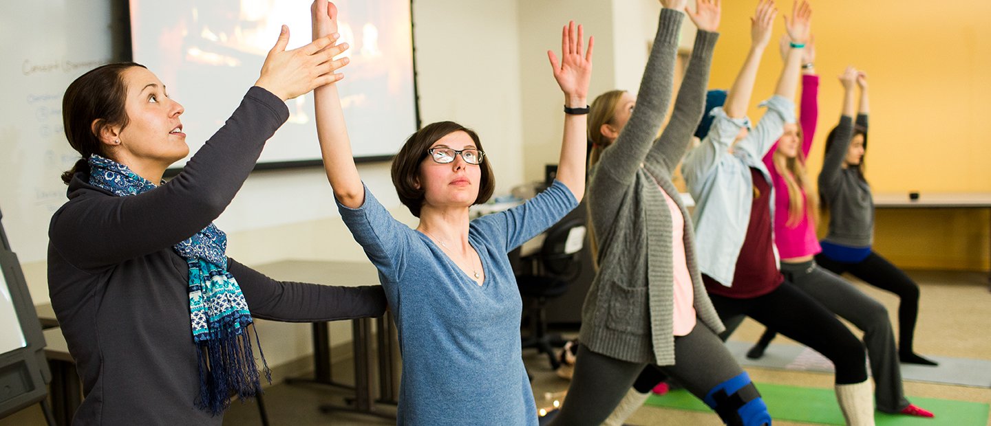 Woman leading a yoga class with five female students