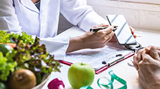 A dietitian showing a client information on a phone.