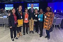 Group of adults at a conference, posing for a photo.