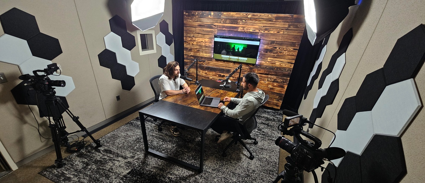 Two people talking in podcast studio