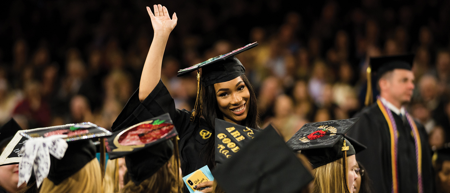 Banner with a woman in here graduation outfit smiling and waving surrounded by other graduates.