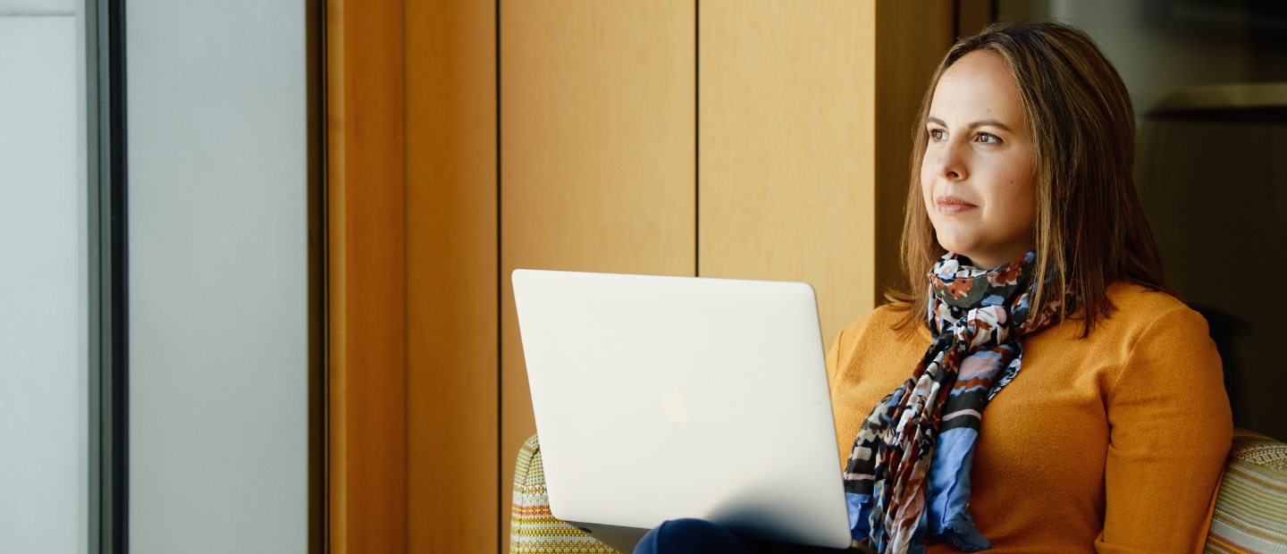 A woman seated with an open laptop
